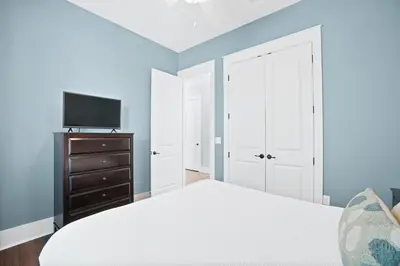 a bedroom with a bed and a tv on a dresser at 30A Beach House - Caspian Sea-duction in Sunnyside