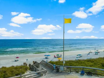a yellow flag on a beach next to the ocean at 30A Beach House - Caspian Sea-duction in Sunnyside