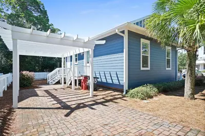 a blue house with a white pergola at 30A Beach House - Caspian Sea-duction in Sunnyside