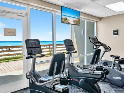 a gym with cardio machines and a view of the ocean at Tidewater 314 NEW in Panama City Beach