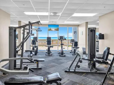 a gym with cardio equipment and a view of the ocean at Tidewater 314 NEW in Panama City Beach