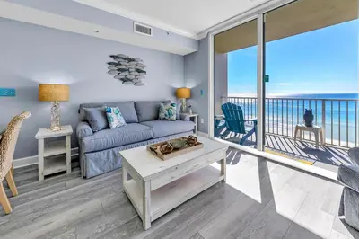 a living room with a couch and a balcony at Tidewater 314 NEW in Panama City Beach