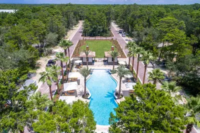 an aerial view of a resort pool with palm trees at Magnolia Cottages by the Sea by Panhandle Getaways in Watersound Beach