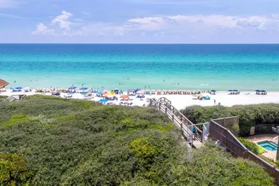 a beach with umbrellas and people on the beach at Magnolia Cottages by the Sea by Panhandle Getaways in Watersound Beach