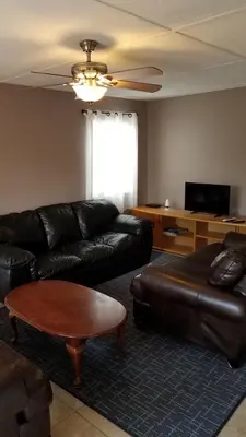 a living room with a leather couch and a coffee table at House 3 blocks to the beach in Panama City Beach