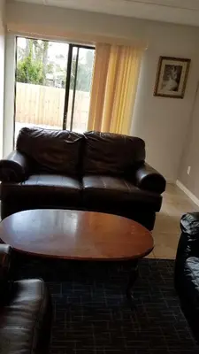 a living room with a leather couch and a coffee table at House 3 blocks to the beach in Panama City Beach
