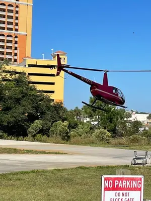 a red helicopter flying over a parking lot with a no parking sign at House 3 blocks to the beach in Panama City Beach