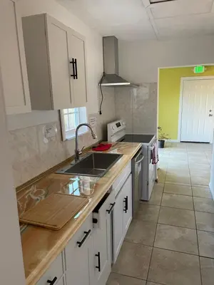 a kitchen with white cabinets and a sink at House 3 blocks to the beach in Panama City Beach