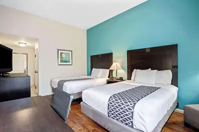 a hotel room with two beds and a flat screen tv at La Quinta by Wyndham PCB Pier Park area in Panama City Beach
