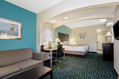 a hotel room with a bed and a couch and a desk at La Quinta by Wyndham PCB Pier Park area in Panama City Beach