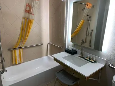 a bathroom with a sink and a tub and a mirror at La Quinta by Wyndham PCB Pier Park area in Panama City Beach