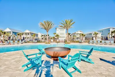a patio with chairs and a table and a pool at Prominence on 30A Vacation Homes in Watersound Beach