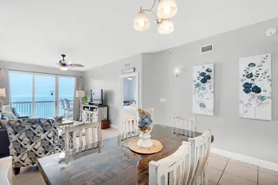 a dining room and living room with a table and chairs at Sunrise Beach #910 in Panama City Beach