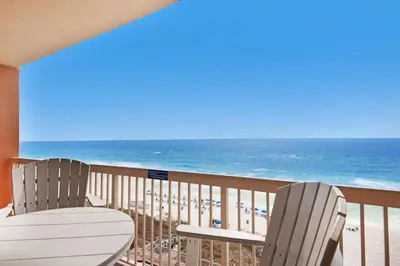 two chairs and a table on a balcony with the beach at Sunrise Beach #910 in Panama City Beach