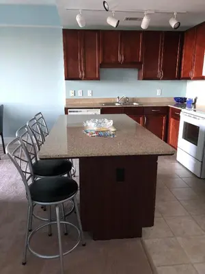 a kitchen with a island with chairs and a counter top at Snowbirds are welcome Laketown Wharf Resort 2 and 3 flrs in Panama City Beach