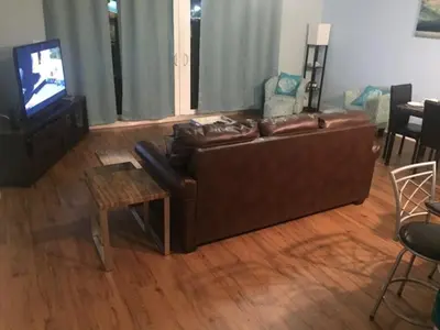 a living room with a brown couch and a tv at Snowbirds are welcome Laketown Wharf Resort 2 and 3 flrs in Panama City Beach