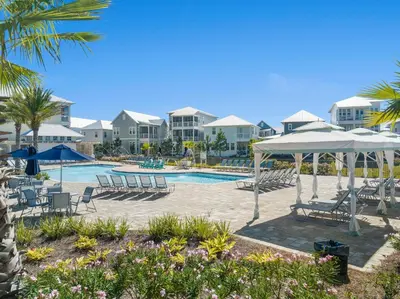 a pool at the resort with chairs and umbrellas at Prominence Rentals on 30A by Panhandle Getaways in Watersound Beach