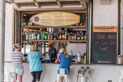 a group of people standing at the counter of a bar at Prominence on 30A by Panhandle Getaways in Watersound Beach