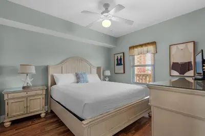 a bedroom with a bed and a ceiling fan at Calypso 1-608 East in Panama City Beach