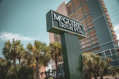 a sign in front of a hotel with palm trees at Majestic Beach Towers 1-1615 in Panama City Beach