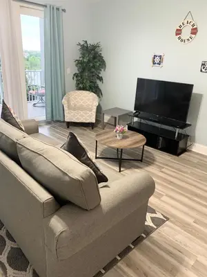 a living room with a couch and a flat screen tv at LAKETOWN 5 POOLs STEPS TO BEACH FAMILY FRIENDLY in Panama City Beach
