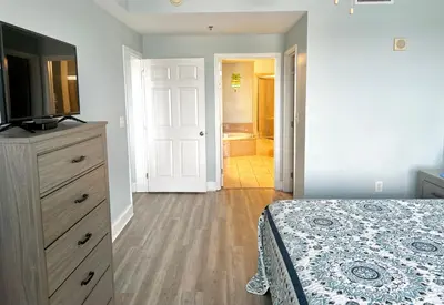 a bedroom with a bed and a dresser with a television at LAKETOWN 5 POOLs STEPS TO BEACH FAMILY FRIENDLY in Panama City Beach