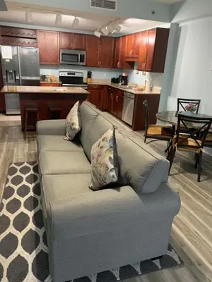 a living room with a couch and a kitchen at LAKETOWN 5 POOLs STEPS TO BEACH FAMILY FRIENDLY in Panama City Beach