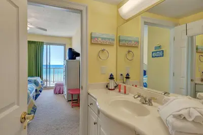a bathroom with a sink and a room with a bed at Oceanfront Condo with Spacious Balcony - Unit 0306 in Panama City Beach