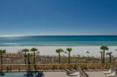 a view of a beach with palm trees and the ocean at Oceanfront Condo with Spacious Balcony - Unit 0306 in Panama City Beach