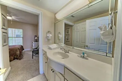 a bathroom with a sink and a mirror and a bed at Beautiful Beachfront Condo with Pool View - Unit 0203 in Panama City Beach