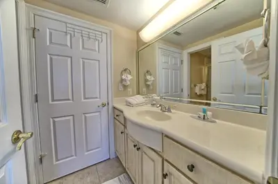 a bathroom with a sink and a large mirror at Beautiful Beachfront Condo with Pool View - Unit 0203 in Panama City Beach
