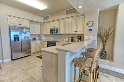 a kitchen with white cabinets and stainless steel appliances at Beautiful Beachfront Condo with Pool View - Unit 0203 in Panama City Beach