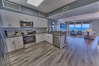 a large kitchen with white cabinets and an open floor plan at Gorgeous Condo with Breathtaking Ocean View - Unit 0803 in Panama City Beach