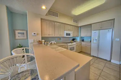 a kitchen with white cabinets and a white refrigerator at Comfortable High-Rise Condo with Beach Access - Unit 1404 in Panama City Beach