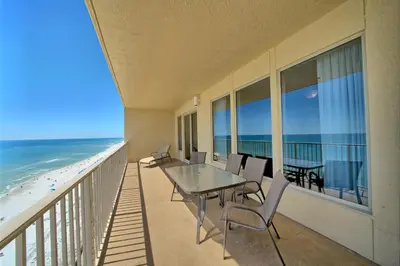 a balcony with a table and chairs and the beach at Comfortable High-Rise Condo with Beach Access - Unit 1404 in Panama City Beach