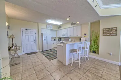 a large kitchen with white cabinets and a counter at Roomy Condo with Pool and Beach Access - Unit 0502 in Panama City Beach