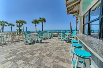 a patio with tables and chairs overlooking the ocean at Luxurious High-Rise Condo with Spacious Balcony Facing the Ocean - Unit 1805 in Panama City Beach