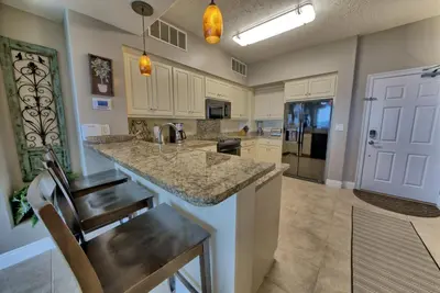 a large kitchen with a counter and a sink at Luxurious High-Rise Condo with Spacious Balcony Facing the Ocean - Unit 1805 in Panama City Beach