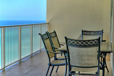 three chairs and a table on a balcony at Luxurious High-Rise Condo with Spacious Balcony Facing the Ocean - Unit 1805 in Panama City Beach