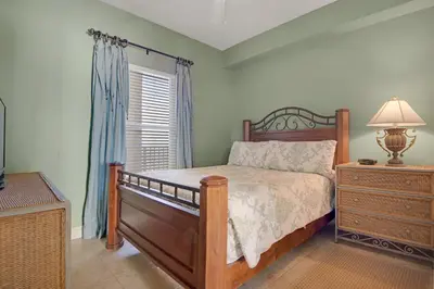 a bedroom with a bed and a dresser and a window at Tropical High-Rise Condo with Beachside Pool Access and Free Poolside WiFi - Unit 2004 in Panama City Beach