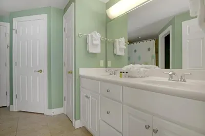 a bathroom with two sinks and a large mirror at Tropical High-Rise Condo with Beachside Pool Access and Free Poolside WiFi - Unit 2004 in Panama City Beach