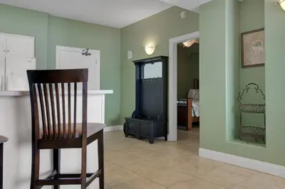 a room with a chair and a television in it at Tropical High-Rise Condo with Beachside Pool Access and Free Poolside WiFi - Unit 2004 in Panama City Beach