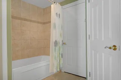 a bathroom with a tub and a shower with a shower curtain at Tropical High-Rise Condo with Beachside Pool Access and Free Poolside WiFi - Unit 2004 in Panama City Beach