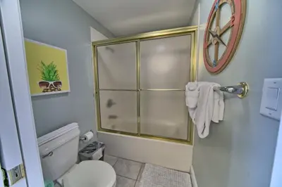 a bathroom with a toilet and a glass shower at Luxurious Beachfront Condo with Beachside Pool Access and Free WiFi - Unit 1202 in Panama City Beach