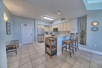 a kitchen with a table and chairs in a room at Luxurious Beachfront Condo with Beachside Pool Access and Free WiFi - Unit 1202 in Panama City Beach