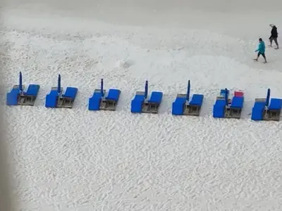 a row of chairs in the sand on a beach at Stylish Oceanfront Condo with Beach and Picnic Area Access - Unit 1706 in Panama City Beach