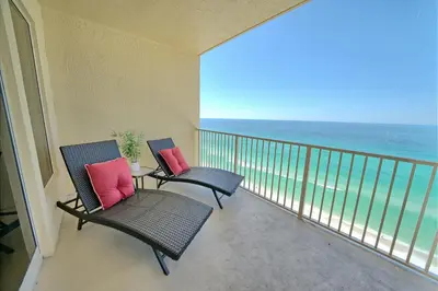 two chairs and a table on a balcony with the ocean at Stylish Oceanfront Condo with Beach and Picnic Area Access - Unit 1706 in Panama City Beach