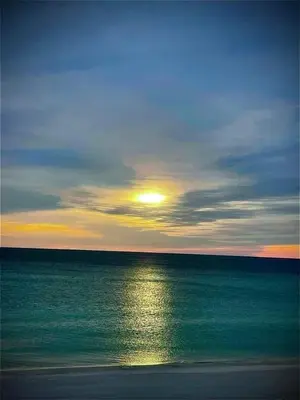 a sunset over the ocean with the sun in the sky at Beautiful Condo with Spacious Balcony to Enjoy Fascinating Ocean View - Unit 1002 in Panama City Beach