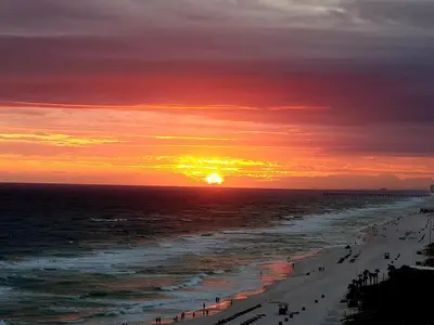 a sunset on the beach with the sun setting at Beautiful Condo with Spacious Balcony to Enjoy Fascinating Ocean View - Unit 1002 in Panama City Beach