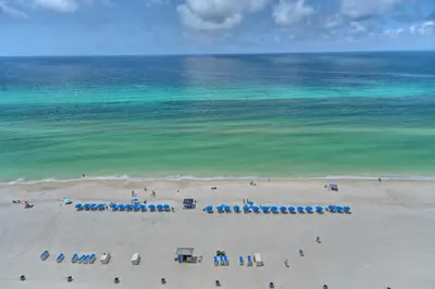 an aerial view of a beach with chairs and the ocean at Pleasant Oceanfront Condo with Large Balcony and Beach Access - Unit 1605 in Panama City Beach